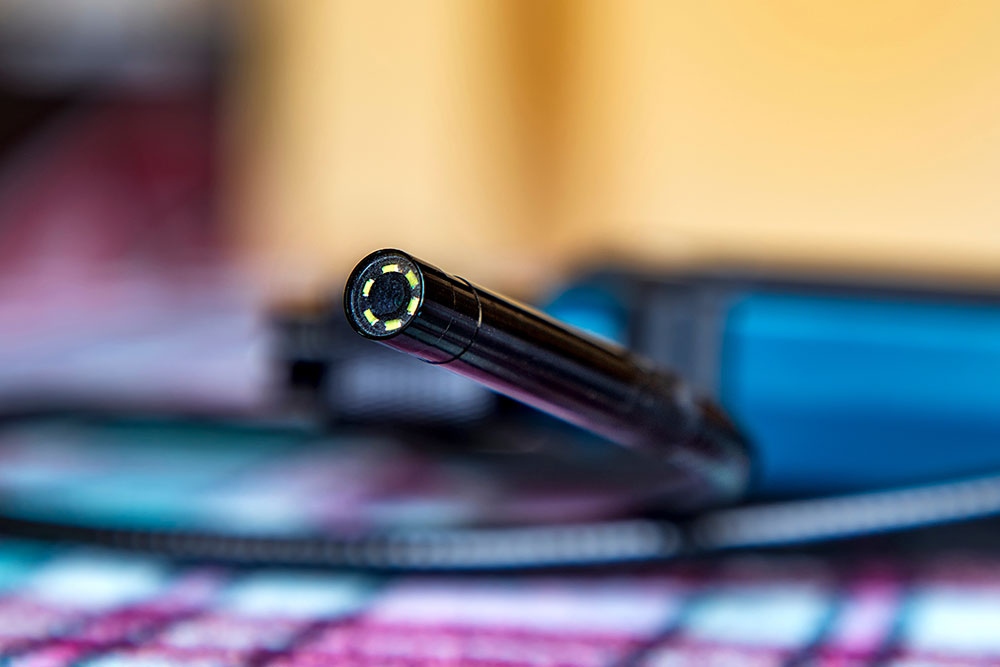 Close-up of a digital borescope camera lens with LED lights, highlighting its inspection capabilities.